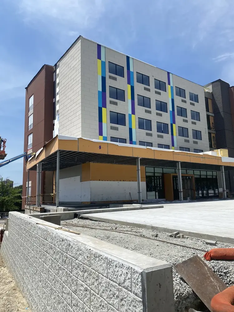 Hotel with grey Dryvit exterior finish, NewBrick, and orange Securock ExoAir 430 air barrier and sheathing panels under construction 