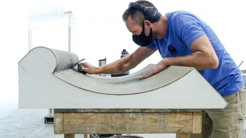 Man in facemask uses trowel on Dryvit architectural shape in manufacturing facility 