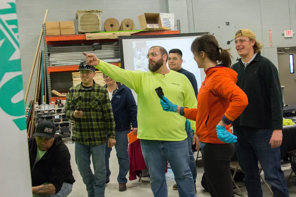 4 people at training demonstrating Tremco sealant and air barrier application.