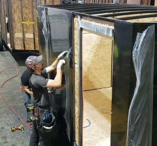 Two in-plant workers assembling a modular unit using Tremco sealants.