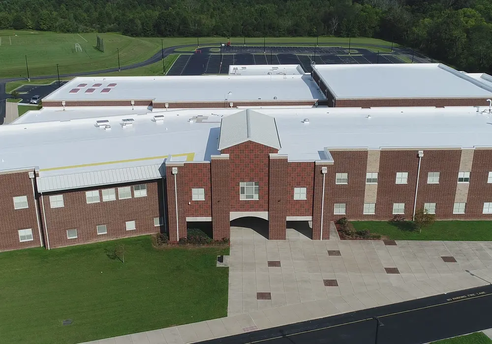 Aerial view of brick school with white roof restored from Tremco