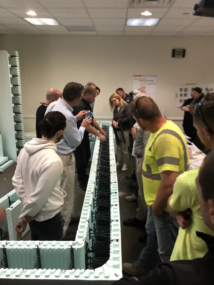 Group of people looking down at Nudura ICFs at training session  