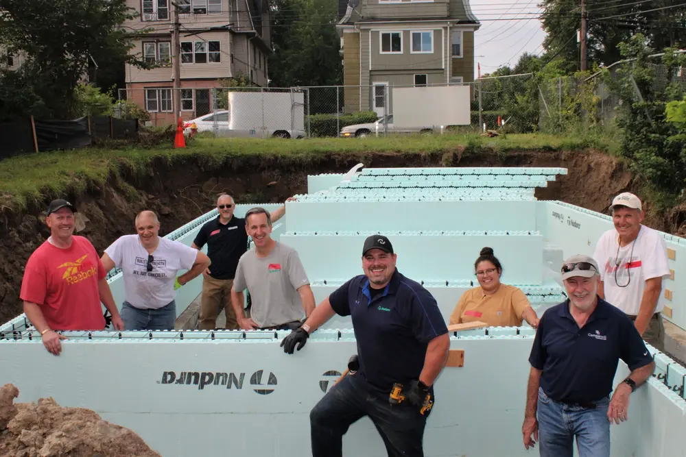 Workers smiling in front of in-progress Nudura ICF construction of an ICF home for Habitat for Humanity